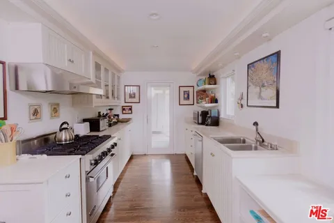 a kitchen with stainless steel appliances a sink stove and cabinets