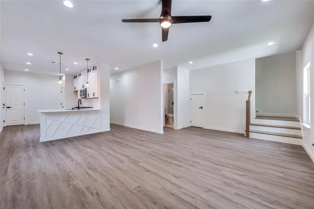 a view of a kitchen with a sink and wooden floor