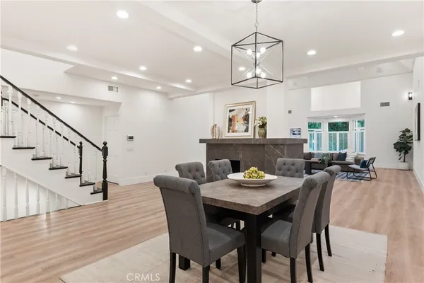 a view of a dining room and livingroom with furniture wooden floor a chandelier