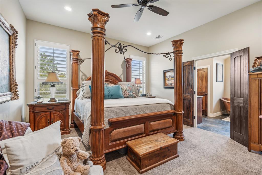 4180 North Smith Road Fate, TX 75087 - Photo 14 of 27 a bedroom with a bed and a chandelier
