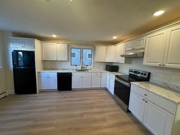 a kitchen with stainless steel appliances granite countertop a refrigerator and a stove top oven