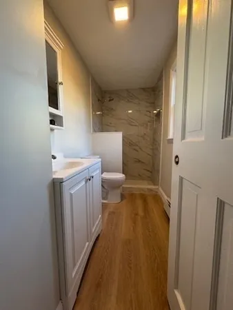 a bathroom with sink a toilet and shower
