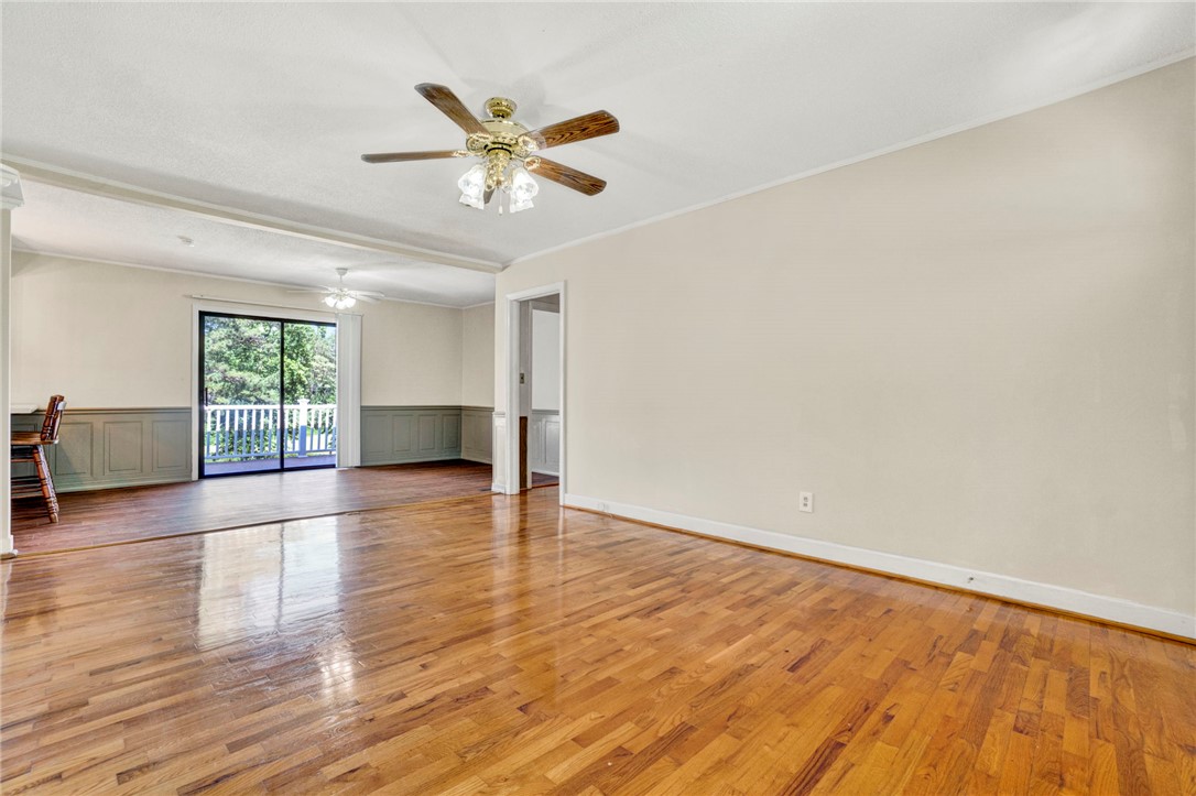 7876 Highway 11 Walhalla, SC 29691 - Photo 17 of 35 Hardwood floors and wainscoting define this welcoming living space with outdoor access.