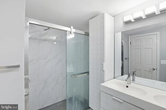 a bathroom with a sink mirror and shower