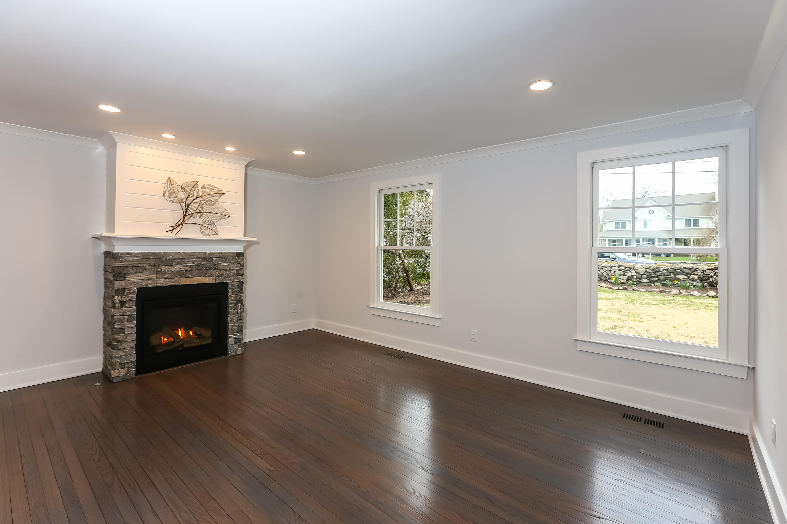 68 Relihan Road Darien, CT 06820 - Photo 4 of 27 a view of an empty room with wooden floor fireplace and a window