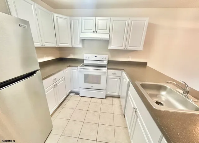 a kitchen with a sink a stove and cabinets