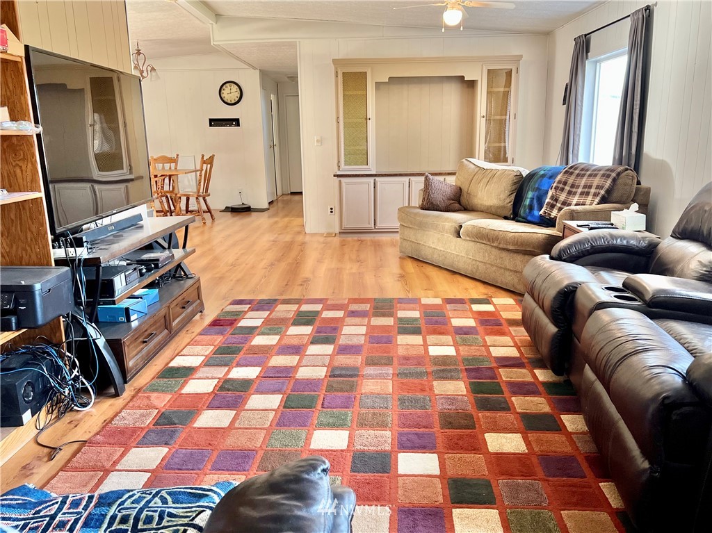 53 Woods Road Omak, WA 98841 - Photo 12 of 40 a living room with a black white checkered floor with a gaming machine and dining table