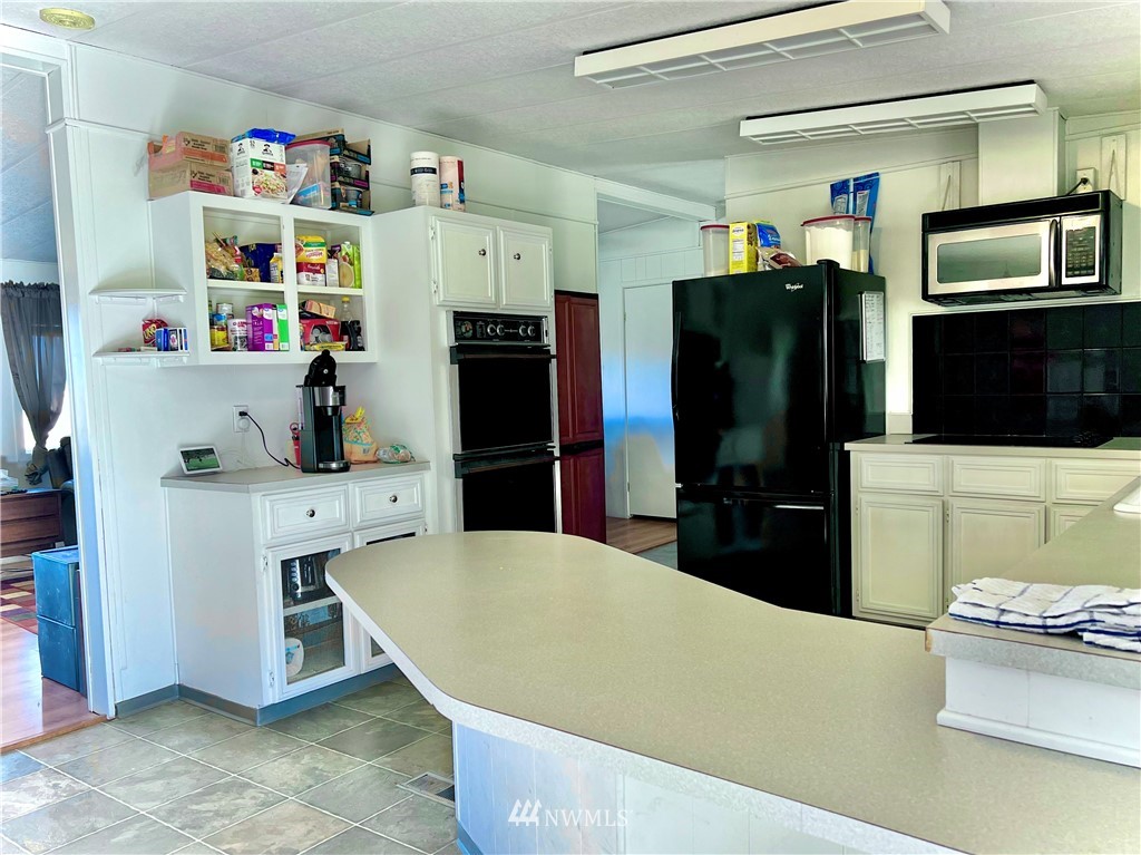 53 Woods Road Omak, WA 98841 - Photo 15 of 40 a kitchen with a refrigerator and a stove