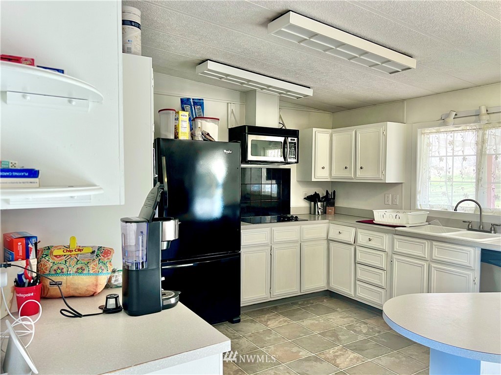 53 Woods Road Omak, WA 98841 - Photo 16 of 40 a kitchen with a sink appliances and cabinets