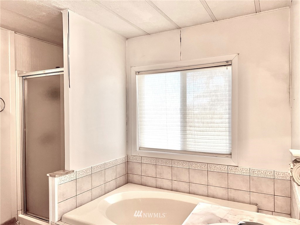 53 Woods Road Omak, WA 98841 - Photo 21 of 40 a bathroom with a bathtub and a window