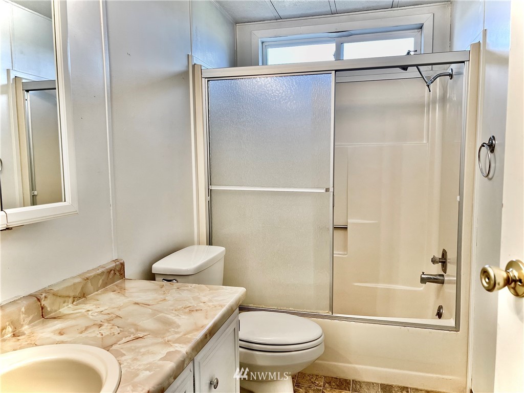 53 Woods Road Omak, WA 98841 - Photo 29 of 40 a bathroom with a granite countertop sink toilet and shower
