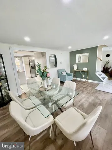 a bedroom with a bed and a dresser with wooden floor