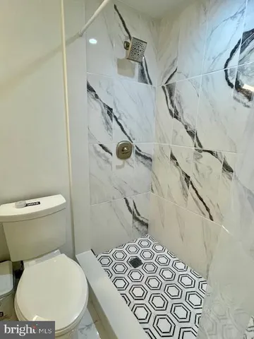 a view of patio with table and chairs under an umbrella with a barbeque