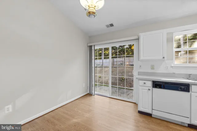 an empty room with windows and cabinet