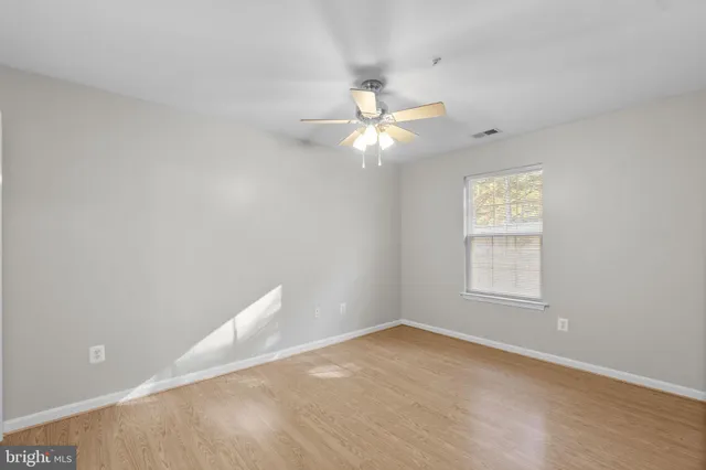 an empty room with windows and fan