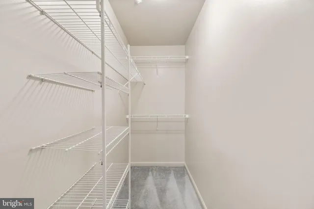 a view of walk in closet with empty racks