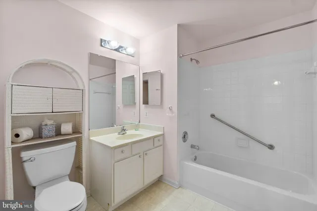 a bathroom with a granite countertop sink a toilet a mirror and shower