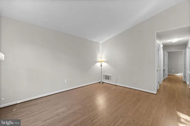 a view of an empty room with wooden floor