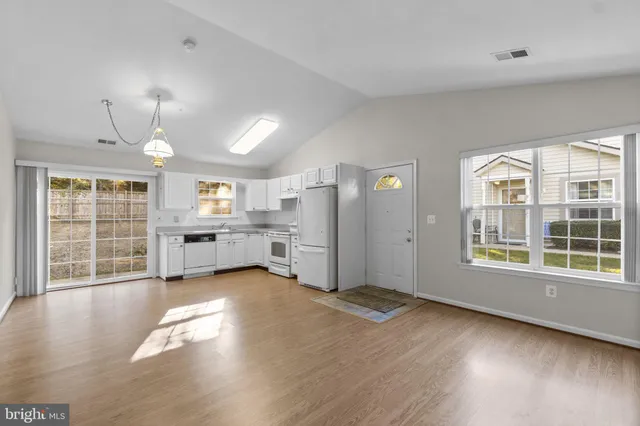 a view of a kitchen with refrigerator and wooden floor