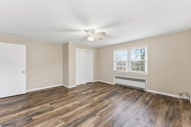 a view of an empty room with window and a ceiling fan