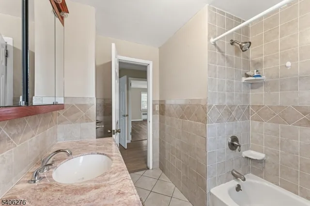 a bathroom with a granite countertop sink a toilet and shower