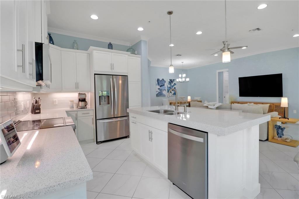 6509 Dominica Drive, Unit 101 Naples, FL 34113 - Photo 10 of 33 a kitchen with kitchen island a sink stainless steel appliances and cabinets