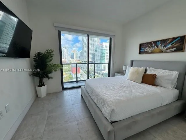 a bedroom with a large bed and a flat screen tv