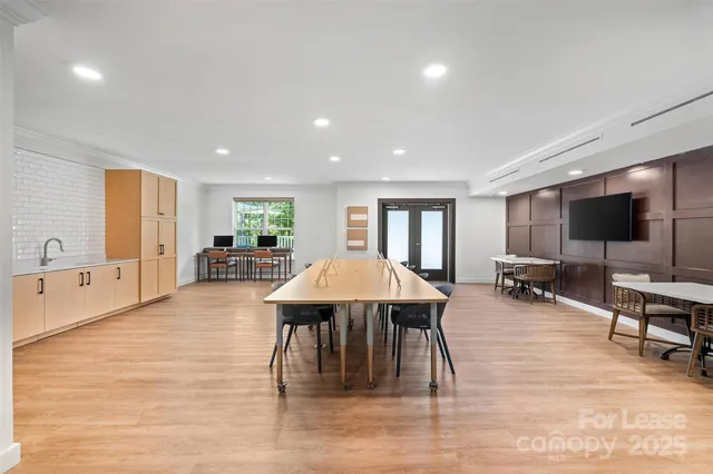 a living room with furniture a flat screen tv and kitchen view