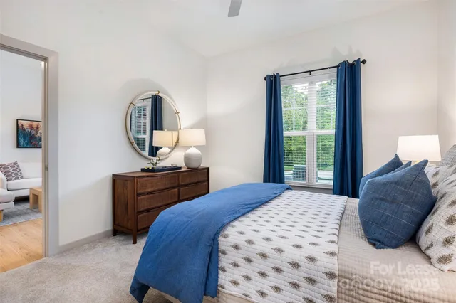 a bedroom with a bed window and a mirror