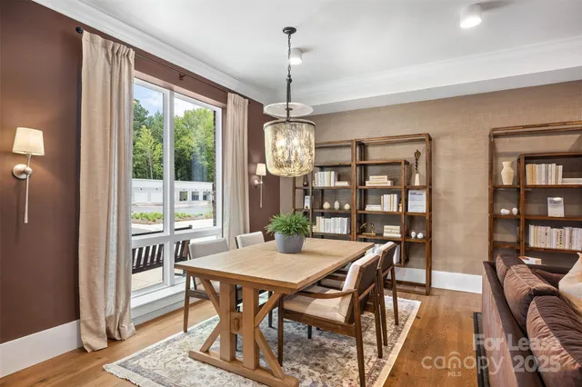 a dining room with furniture a chandelier and wooden floor