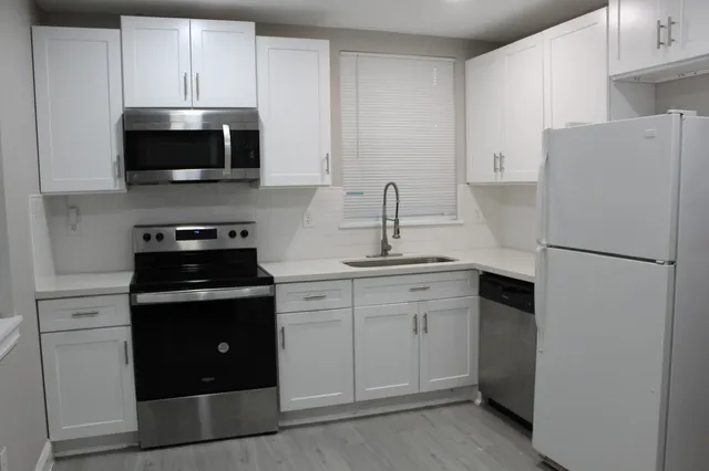 a kitchen with a sink and steel appliances
