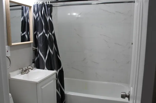 a bathroom with a sink a mirror and a shower