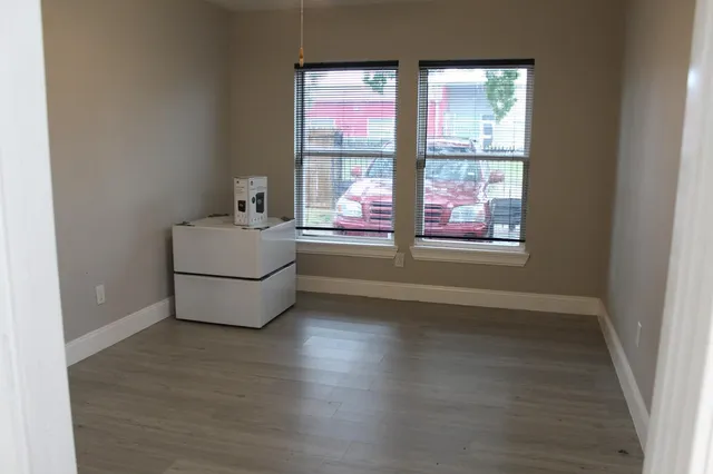 a room with wooden floor and windows