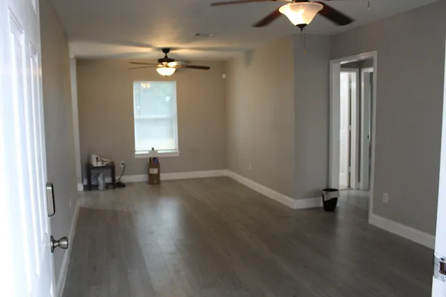 wooden floor in an empty room with a window