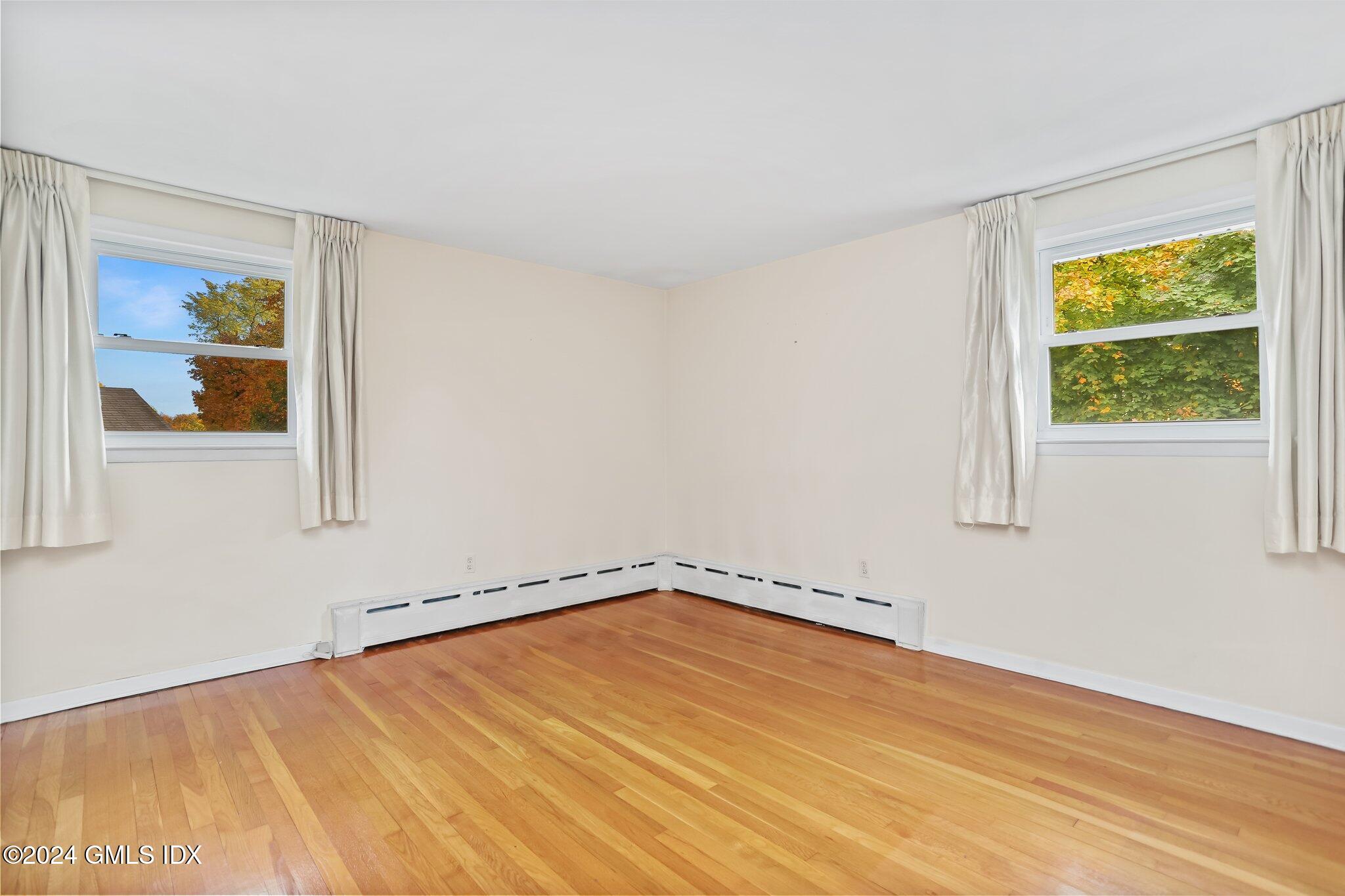 20 Norias Road Greenwich, CT 06830 - Photo 20 of 40 a view of empty room with window and wooden floor