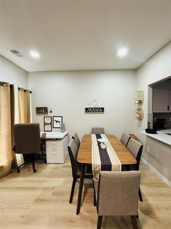 Wood-finish flooring, recessed lighting, and a built-in countertop with an under-mount sink