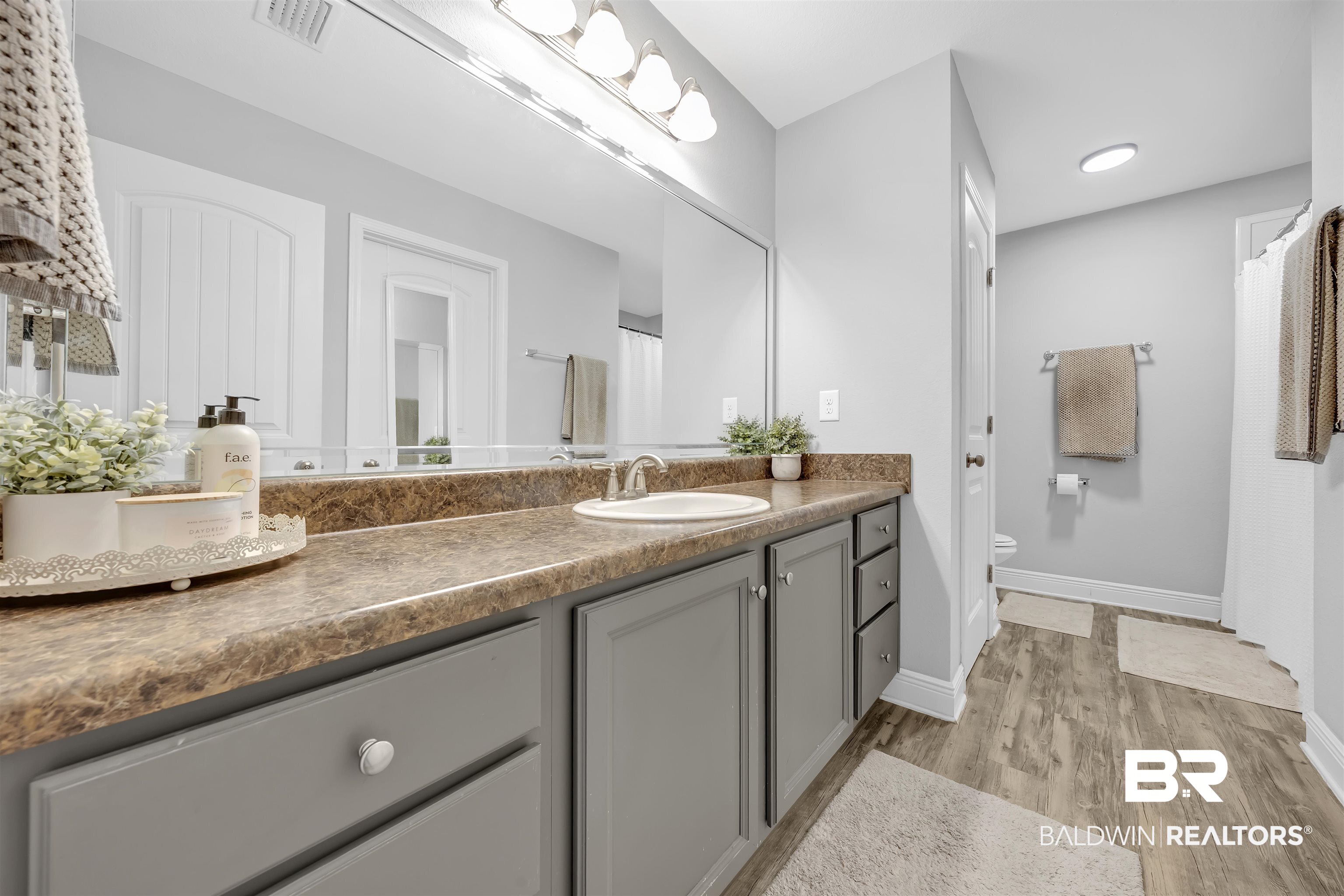 15570 Medway Court Foley, AL 36535 - Photo 13 of 25 Bathroom with vanity, light wood finished floors, and a shower with shower curtain