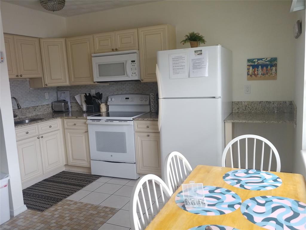 120 Northeast 20th Avenue, Unit 3 Deerfield Beach, FL 33441 - Photo 5 of 14 a kitchen with a stove a sink and a refrigerator