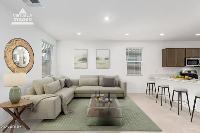 a living room with furniture a rug a window and a flat screen tv