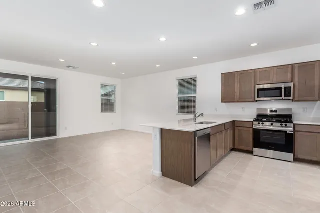 a large kitchen with stainless steel appliances granite countertop a large counter top and a stove top oven