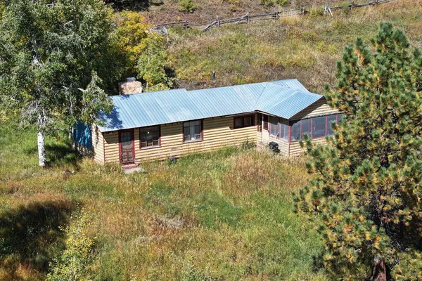 a aerial view of house with yard and trees in the background