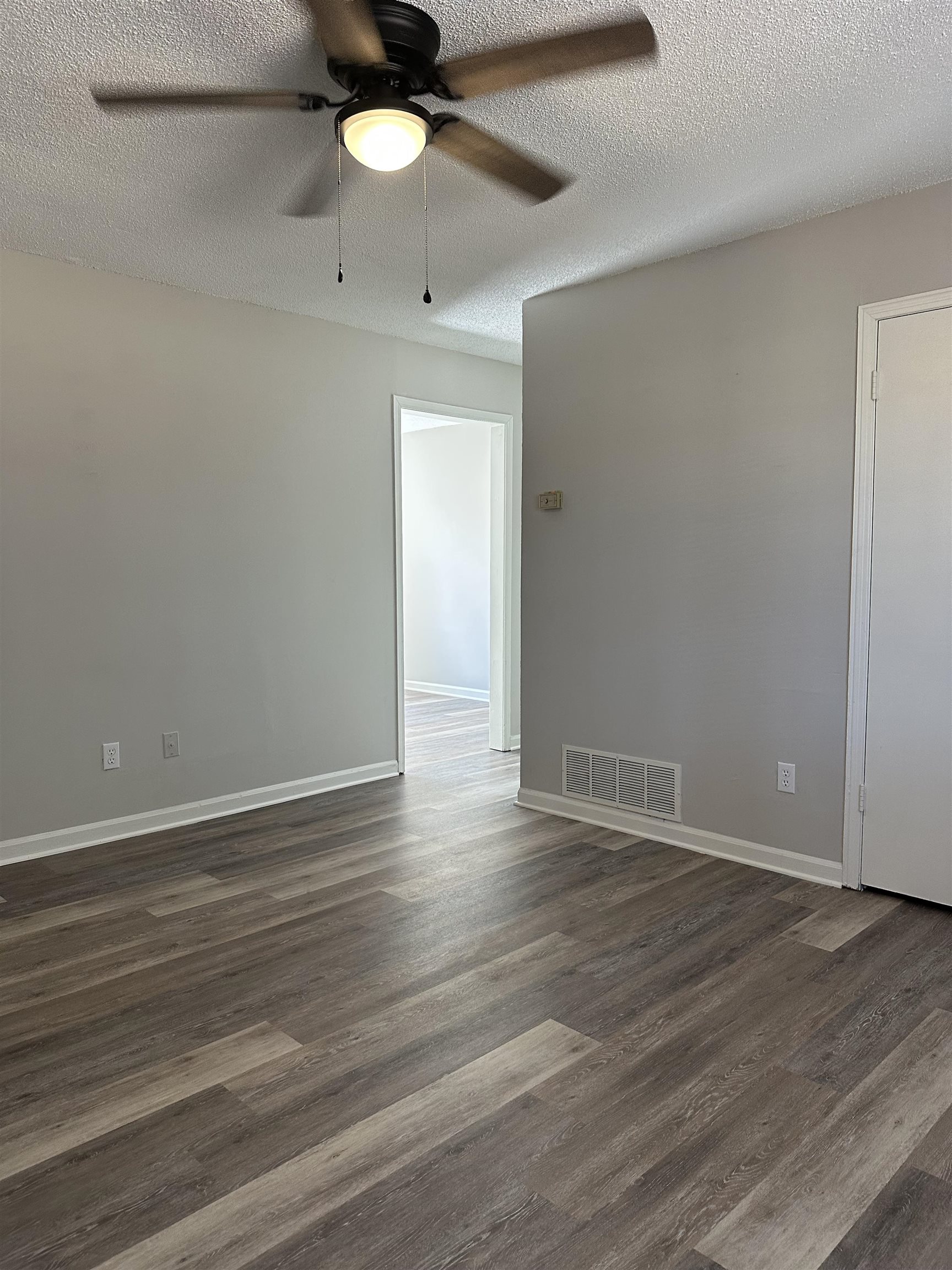 899 West Raines Road Memphis, TN 38109 - Photo 4 of 14 Wood-finish flooring, light gray walls, white trim, and a ceiling fan with integrated lighting