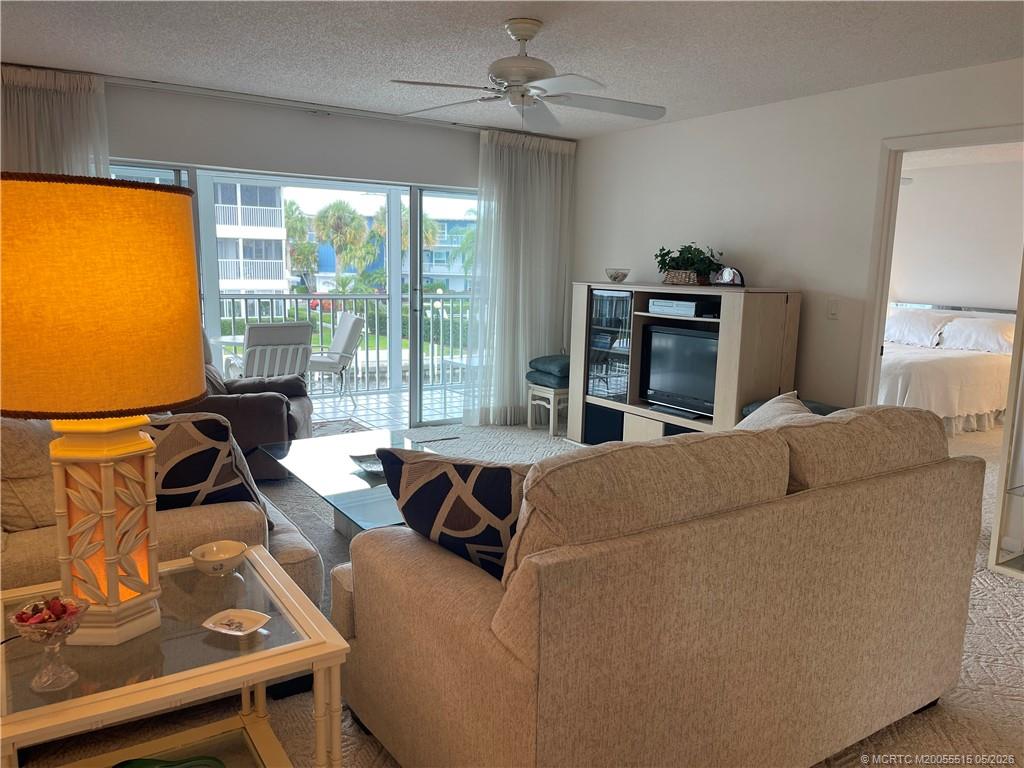 1858 Southwest Palm City Road, Unit 203 Stuart, FL 34994 - Photo 11 of 21 a living room with furniture and a floor to ceiling window