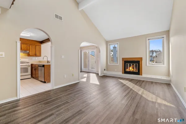 a view of a livingroom with wooden floor and a fireplace