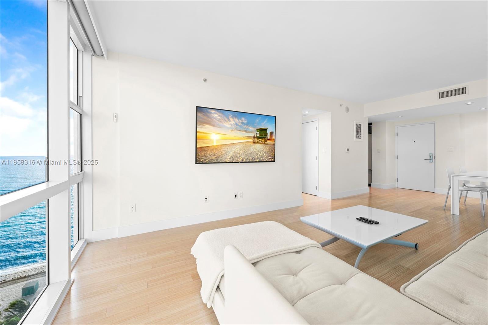 6801 Collins Avenue, Unit DOOR1409 Miami Beach, FL 33141 - Photo 2 of 21 a living room with a bed and a table