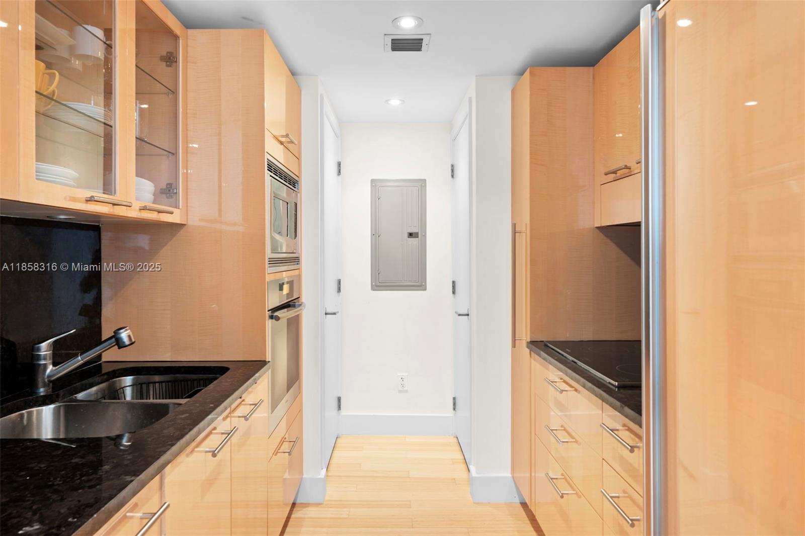 6801 Collins Avenue, Unit DOOR1409 Miami Beach, FL 33141 - Photo 7 of 21 a kitchen with granite countertop a sink and a refrigerator