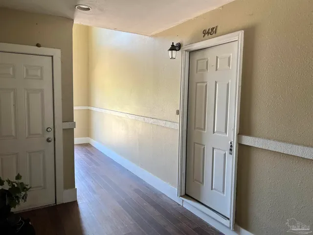 a view of empty room with wooden floor