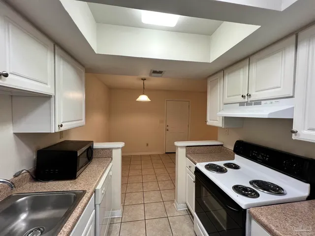 a kitchen with stainless steel appliances a stove a sink and a microwave