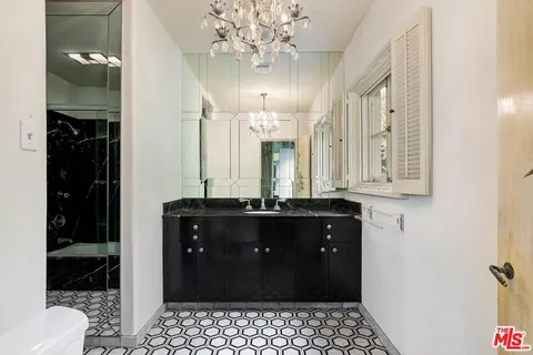 a bathroom with a double vanity sink a toilet and a mirror