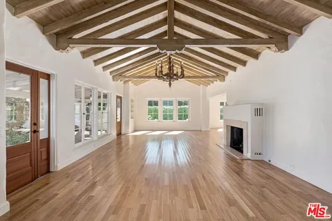 a view of empty room with wooden floor and fireplace